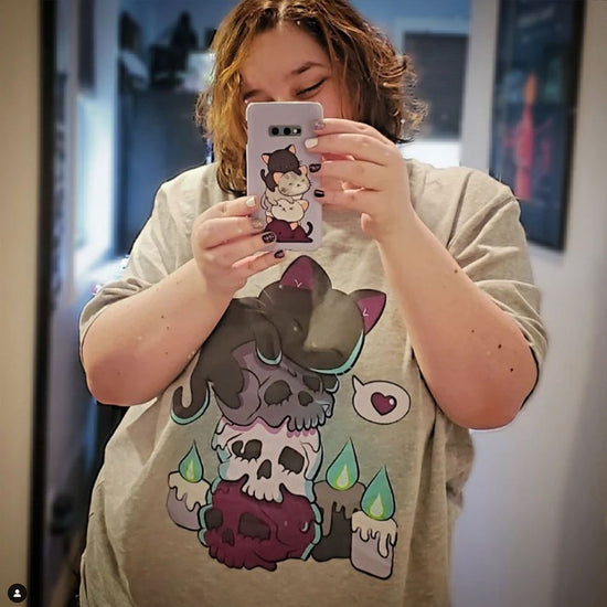 Happy customer wearing Asexual Pride Aesthetic Cat on Skulls Kawaii Shirt and holding Asexual Pride Kawaii Cat Phone Case in her hands